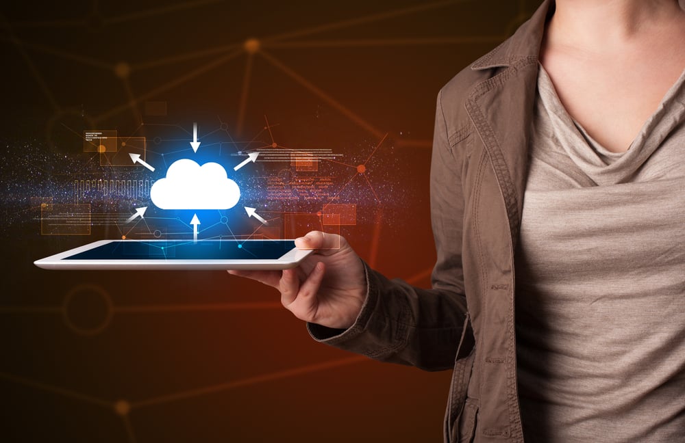 Casual young woman holding tablet with cloud concept